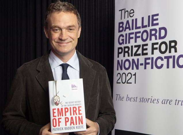 Patrick-Radden-Keefe holding a book titled 'Empire of Pain' with a sign for the Baillie Gifford Prize for Non-Fiction 2021 in the background.