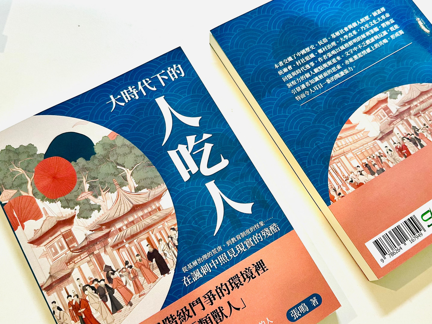 從廟會到文革，張鳴寫下中國社會最荒唐也最真實的一面 Two copies of the Chinese novel 'The People Eater' (大時代下的人吃人) by Feng Qiao, showing both the front cover with traditional Chinese ink-wash illustration and the back cover with a blue wave pattern and crowd illustration.